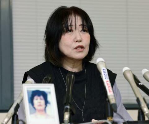 　神戸市役所で記者会見する佐藤悦子さん。手前は母正子さんの写真＝１３日午後