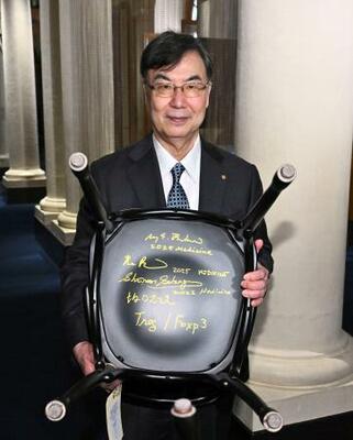 　ストックホルムのノーベル博物館を訪問し、椅子の裏に書いたサインを披露する坂口志文・大阪大特任教授＝６日（ロイター＝共同）