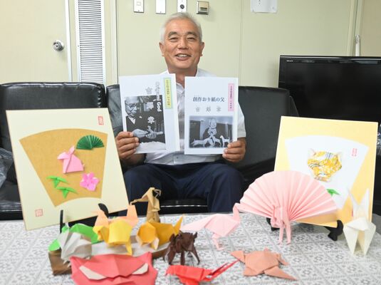 完成した教本を手にする氷室教育長