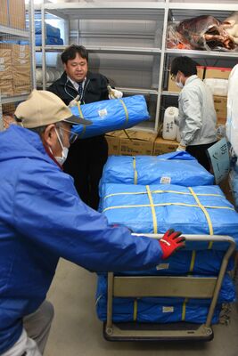 倉庫からブルーシートを運び出す益子町の職員＝４日午後２時３０分、益子町益子