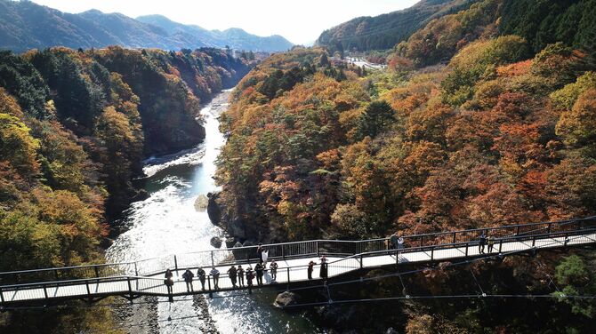 鬼怒川温泉の鬼怒楯岩大吊橋で渓谷美と紅葉を楽しむ人たち＝2022年11月