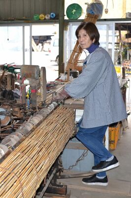 機械で１本ずつヨシを編む栗田さん