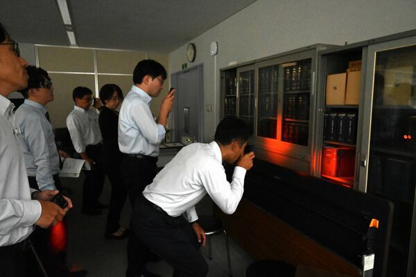 探知機を使って盗撮カメラを模した機器を探す県教委職員=25日午後2時10分、県庁南別館