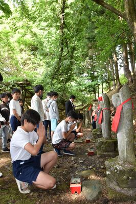 地蔵に向かって手を合わせる児童ら