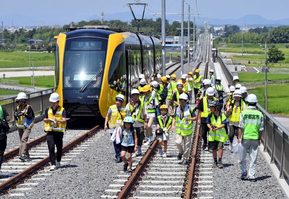 起伏のあるＬＲＴの専用軌道を歩く参加者たち＝29日午前11時、宇都宮市竹下町