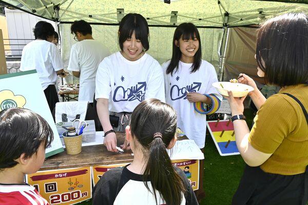 イベントで輪投げなどのブースを運営する由梛さん（左）と俐亜さん