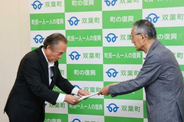 福島県双葉町の伊沢史朗町長(左)に報告書を手渡す田中俊一委員長=6日午前、双葉町役場