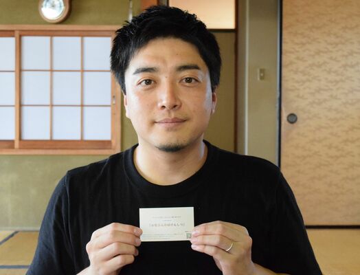 配布している相談窓口案内カードを手にする土橋代表理事＝８月下旬、宇都宮市弥生２丁目