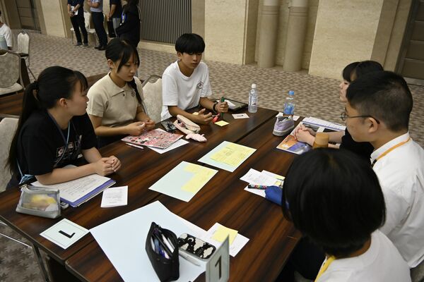 グループになって地元の戦争体験などを話す参加者たち＝７日午前、広島市