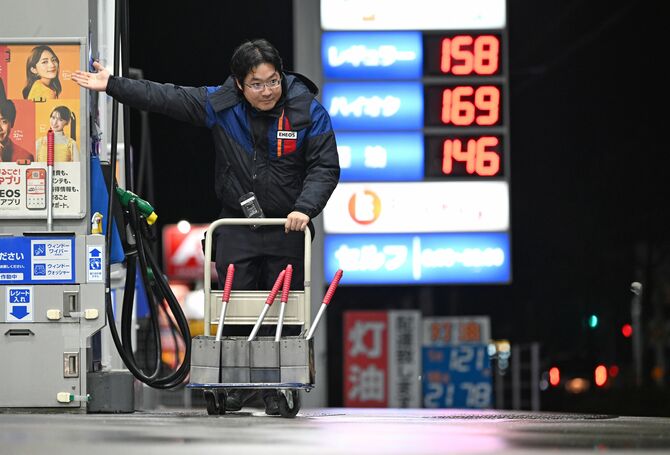 来店客の車を誘導する小林達宏さん＝2025年12月24日午後７時５分、日光市今市