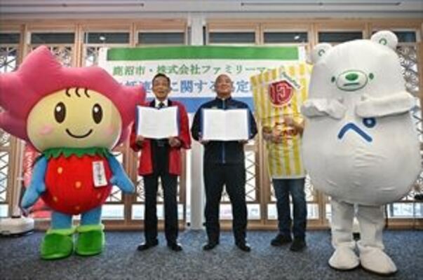 協定書を掲げる水野さん（中央）と佐藤市長（左）