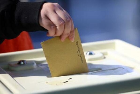 15日、フランス南部マルセイユの投票所で投票する女性(ロイター=共同)