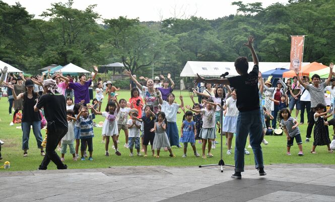 那珂川河畔公園で８月下旬に行われた催しで、「パプリカ」に合わせて踊る子どもたち