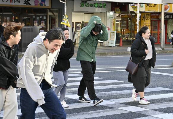 冷たい強風にフードを被るなど寒さをこらえて歩く通行人＝13日午後３地３０分、宇都宮市馬場通り１丁目