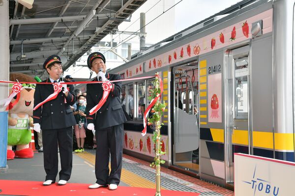 Ｕ字工事のかけ合いでお披露目された東武鉄道のラッピング列車「ベリーハッピートレイン」＝10日午前９時30分、宇都宮市宮園町