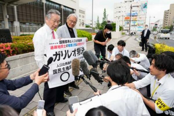 衆院選の「1票の格差」訴訟の判決を受け、広島高裁岡山支部前で取材に応じる原告側の升永英俊弁護士(奥左)ら=28日午後
