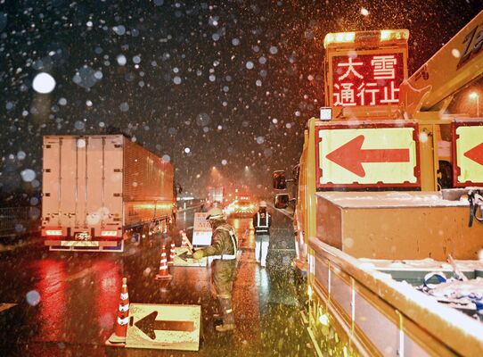 予防的通行止めが行われ、国道４号から側道へ入るトラック＝４日午後７時55分、那須塩原市鍋掛