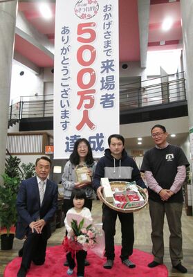 来場者５００万人目となった道地さん家族（中央）ら（道の駅きつれがわ提供）