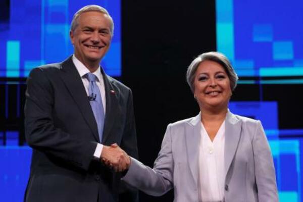 テレビ討論会に参加し握手を交わすチリ大統領候補のハラ前労働・社会保障相(右)とカスト元下院議員=9日、サンティアゴ(ロイター=共同)