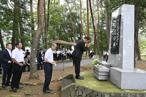 慰霊碑に献花する参列者＝２日午前、宇都宮市西川田４丁目