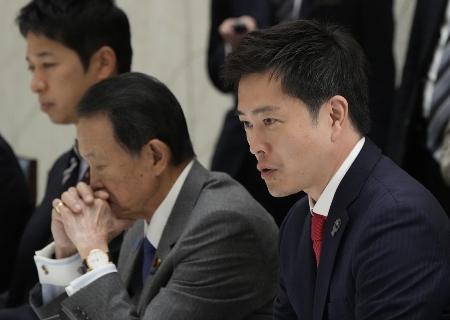 　12月１日の政府与党連絡会議で発言する吉村氏（右）。直後に高市首相と党首会談、比例代表50削減の主張を転換し小選挙区25・比例代表20の削減案を受け入れた＝官邸