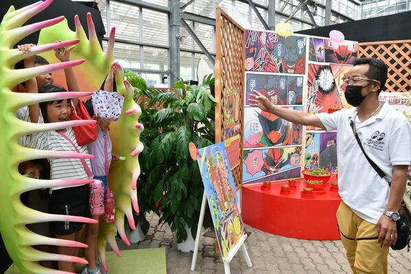 ハエトリグサの葉のオブジェに入って遊ぶ親子連れ