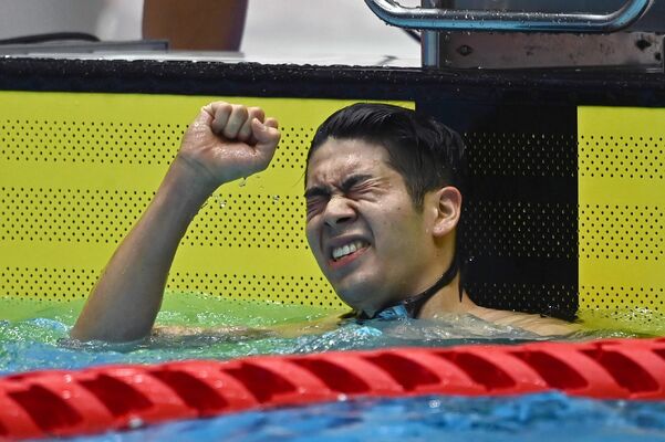 成年男子100メートルバタフライ決勝で接戦を制して優勝し、ガッツポーズをする水沼＝17日午後４時15分、日環アリーナ栃木屋内水泳場