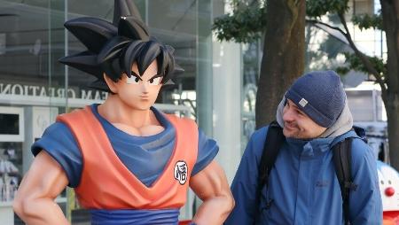 　漫画家鳥山明さんの代表作「ドラゴンボール」のキャラクターの像を見つめる外国人観光客＝24年３月、東京都台東区