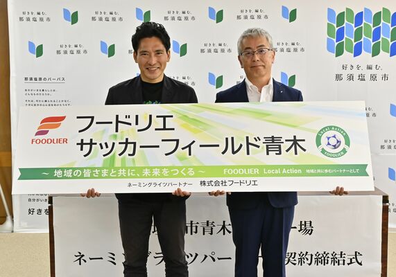 愛称が書かれたプレートを持つ渡辺市長（左）と内田社長