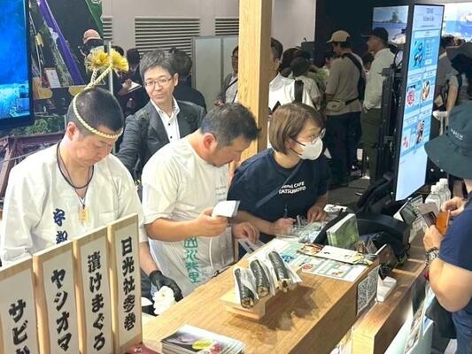 大阪・関西万博でサビかんを販売する鈴木さんら(町提供)