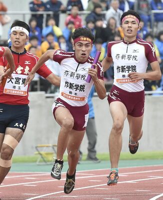 男子４００メートルリレー決勝　作新の三走・中里（右）からバトンを受け取り走り出すアンカーのマデロ＝正田醤油スタジアム群馬