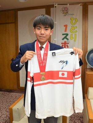 優勝メダルとユニホームを披露する幾田さん
