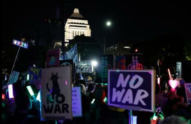 国会前で開かれた平和憲法の維持を求める市民団体の集会=8日夜