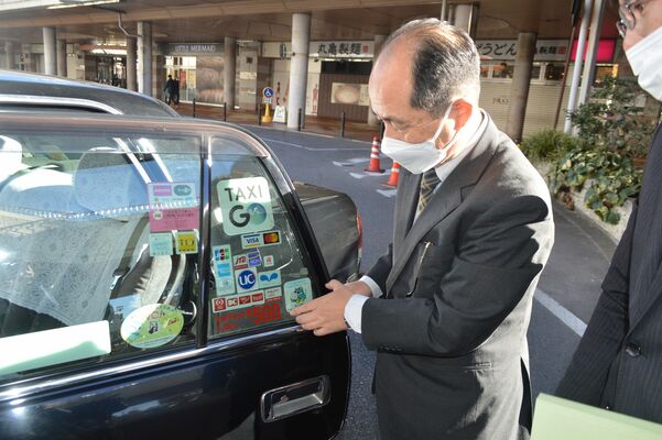 ステッカーの表示位置を確認する古谷野支局長＝４日午前、宇都宮市川向町
