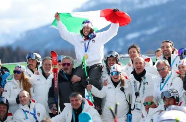 　アルペンスキー女子スーパー大回転で金メダルを獲得し、国旗を掲げて喜ぶイタリアのフェデリカ・ブリニョネ＝１２日、コルティナダンペッツォ（ロイター＝共同）