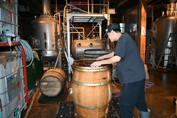 ウイスキー原酒の樽詰め準備を行う日光街道小山蒸溜所の従業員=小山市
