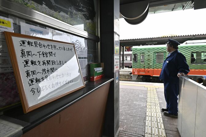 地震による運転見合わせを知らせる白板と、下館～真岡駅間の部分再開後、最初に真岡駅に到着した下り列車＝１日午前11時35分、真岡駅、森田大地撮影