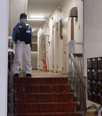 冷凍庫に入った男性の遺体が見つかった集合住宅を警戒する警察官=20日午後9時26分、神戸市中央区