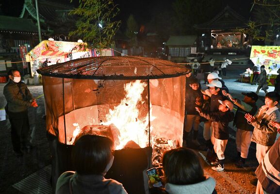 煙を浴びる参列者ら。奥には出店が並び、太々神楽も披露した