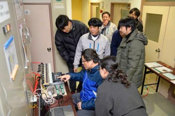 放射線防護施設で測定した気圧を確認する研究チーム=14日午後、新潟県柏崎市