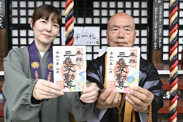 七夕のデザインの御朱印を持つ川田さん(左)。小田住職(右)が持つのはアサガオにちなんだ御朱印