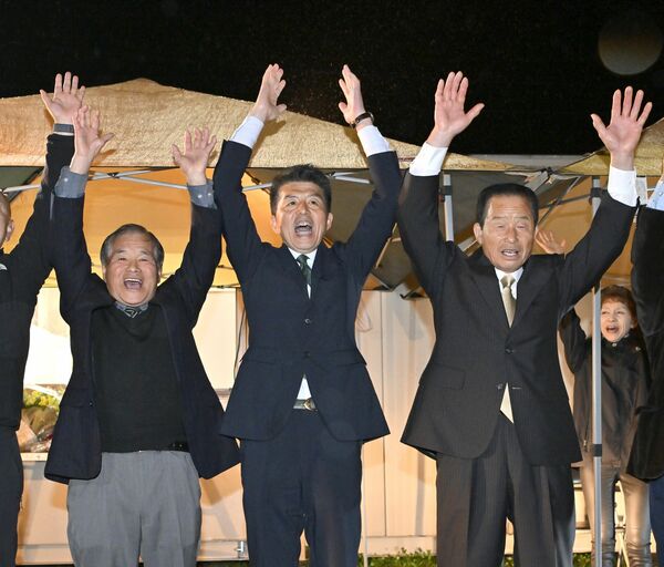 初当選し、万歳する中村卓資氏(中央)=13日午後9時45分、さくら市馬場、森田大地撮影