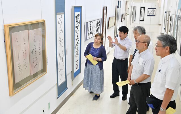 下野書展賞に選ばれた作品（左）を講評する審査員＝29日午後５時５分、宇都宮市インターパーク６丁目
