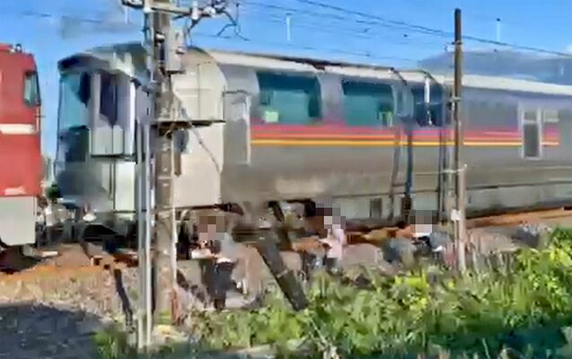 警笛を鳴らして通過するカシオペアと線路脇で撮影していたとみられる３人＝３日午後６時過ぎ、矢板市内（撮影者提供・画像は一部加工しています）
