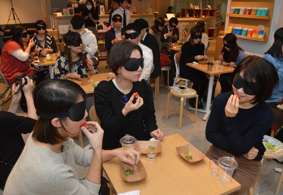 アイマスクをした状態で大田原市産イチゴを味わう参加者たち＝１４日夜、東京・渋谷