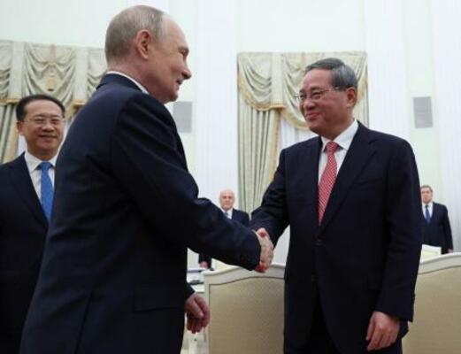 中国の李強首相(右)と握手するロシアのプーチン大統領=18日、モスクワ(ロイター=共同)