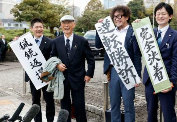 猟銃所持許可取り消しを巡る訴訟の最高裁判決で勝訴し、笑顔を見せる北海道猟友会砂川支部長の池上治男さん(左から2人目)ら=27日午後、東京都千代田区