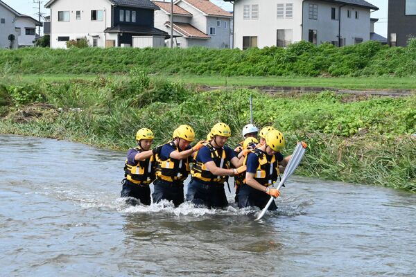 隊列を組んで河川を横断する佐野署員ら