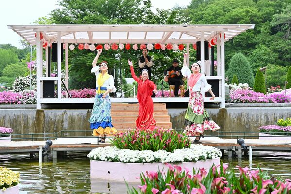 花に囲まれた特設ステージで踊りを披露する吉澤さん(中央)ら