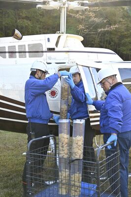 散布する経口ワクチンをヘリコプターに積み込む作業員＝４日午前、日光市